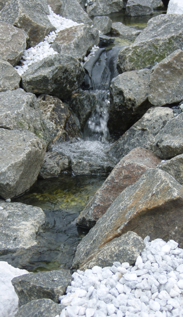 Klippestykker og granitsten som vandsten og springvand i haven